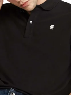 Polo en coton noir uni avec une coupe droite et un col boutonné