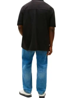 Polo en coton noir uni avec une coupe droite et un col à revers zippé