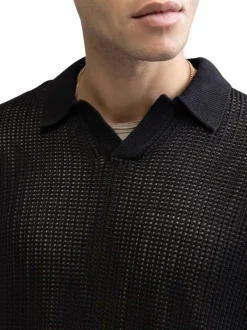 Polo en coton noir uni en maille ajourée avec une coupe droite