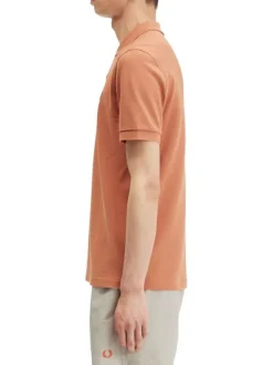 Polo en coton orange uni avec une coupe droite et un petit logo sur la poitrine