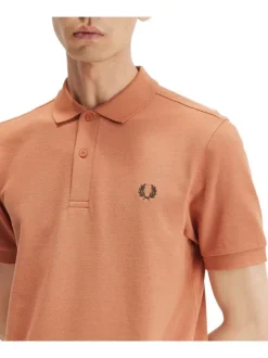 Polo en coton orange uni avec une coupe droite et un petit logo sur la poitrine