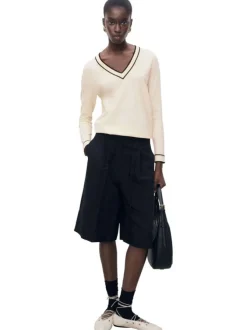Pull beige en maille fine avec une coupe droite et un col v rayé