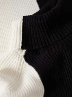 Pull black bicolore coupe droite avec un col roulé et des manches en bord côte