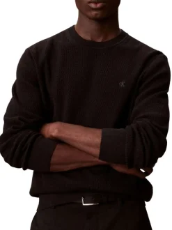 Pull en coton noir uni en maille avec un col rond et le mini logo brodé