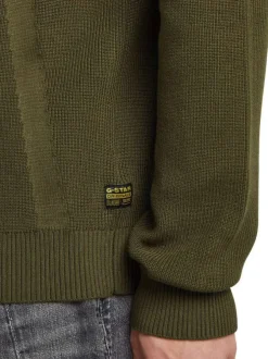 Pull en coton vert uni avec un col rond et un patch d'authenticité
