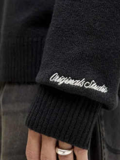 Pull noir uni en maille fine avec un col camionneur et des manches longues