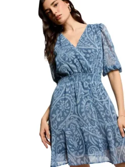 Robe courte bleue à motif floral avec une coupe cintrée et un col croisé