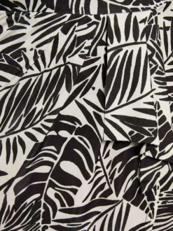 Robe courte noire et blanche pourvue d'un col v croisé et de manches courtes