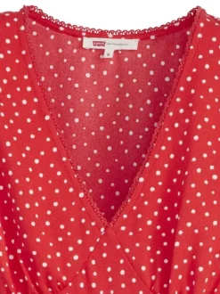 Robe courte rouge à pois blancs avec une coupe droite fluide et un col v