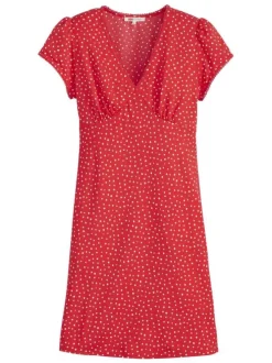 Robe courte rouge à pois blancs avec une coupe droite fluide et un col v