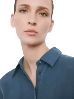 Robe longue bleue unie pourvue d'une coupe cintrée et d'un col chemise