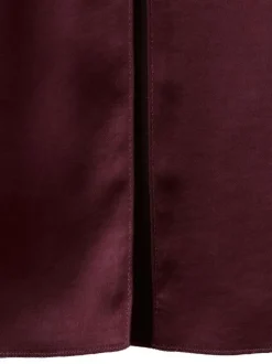 Robe longue bordeaux en tissu satiné pourvue d'un col montant