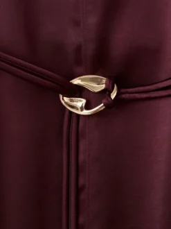 Robe longue bordeaux en tissu satiné pourvue d'un col montant