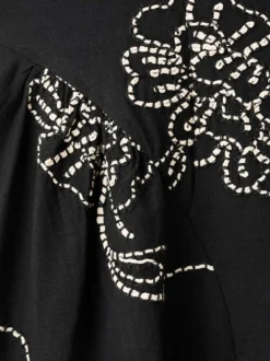 Robe longue noire unie pourvue de broderies florales contrastées