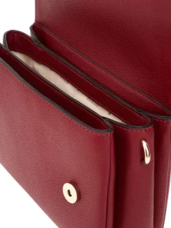Sac bandoulière rouge uni avec le nom de la marque en pièces métalliques