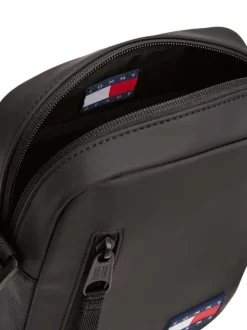 Sacoche noire unie avec un patch d'authenticité à l'avant et un zip