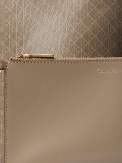Sac porté épaule taupe muni d'une anse ajustable avec des motifs monogrammes