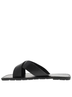 Sandales noires à talon plat avec marque imprimée sur la semelle