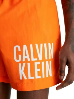 Short de bain orange uni avec une poche arrière et nom de la marque