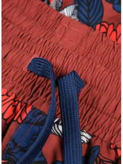 Short de bain rouge avec des motifs floraux all over et un patch