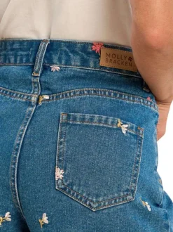 Short en coton indigo pourvu de motifs floraux brodés et de multiples poches