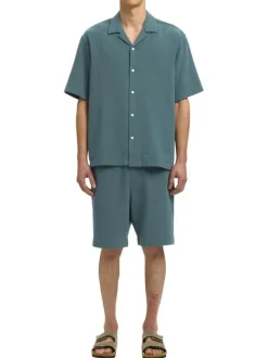 Short en coton vert uni pourvu d'une taille élastiquée et d'une coupe droite