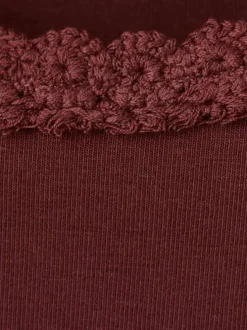 Top bordeaux uni avec une coupe moulante et un col rond à dentelle