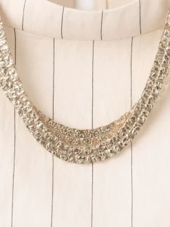 Top écru à rayures avec une coupe cropped et un bijou au col