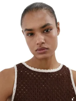 Top marron uni pourvu de détails de fleurs brodées blanches