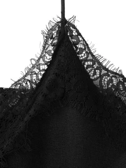 Top noir uni sans manche pourvu d'une coupe asymétrique et d'un col v