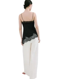 Top noir uni sans manche pourvu d'une coupe asymétrique et d'un col v