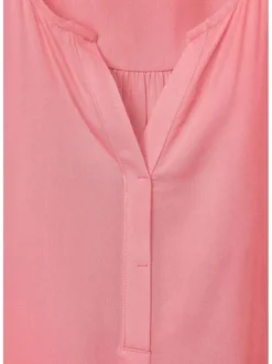 Top rose uni sans manches avec une matière fluide et un col fendu