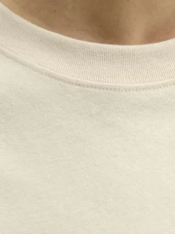 T-shirt en coton écru avec un logo orange brodé et une coupe droite